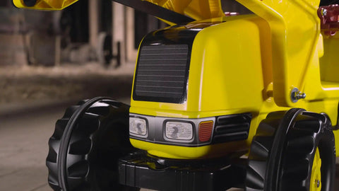 Close-up of bright yellow front loader on Construction Pedal Tractor With Front Loader And Detachable Trailer For Kids Ages 2.5 And Up