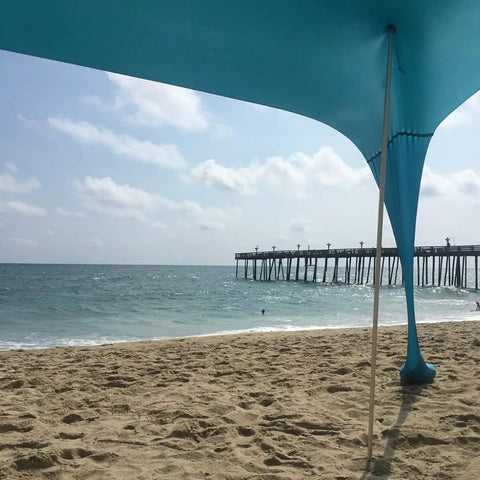 Beach shade canopy setup with Replacement Tent Poles For Canopy And Beach Shade 6.5 Foot Aluminum Poles Set for camping, ocean view.