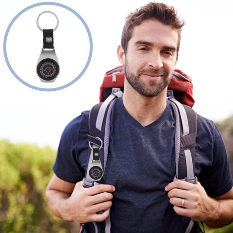 Mini Zinc Alloy Compass Keychain Set For Outdoor Adventures attached to hiker's backpack, close-up view of the compass detail.