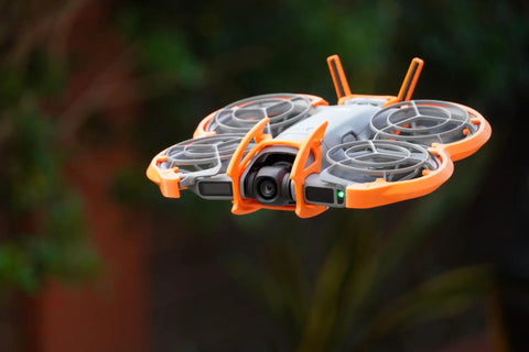 Drone Protection Accessories Kit For DJI Neo 2 Restores Flight Safety With Propeller Guards, shown in flight with orange guards.