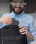 Person placing Portable Conference Speaker And Microphone With 360 Degree Voice Pickup USB C And Bluetooth into backpack