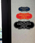 Three Employees Only signs in different colors and designs mounted on a wall, indicating restricted access for staff in workspaces.