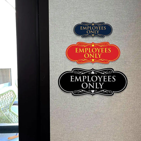 Three Employees Only signs in different colors and designs mounted on a wall, indicating restricted access for staff in workspaces.