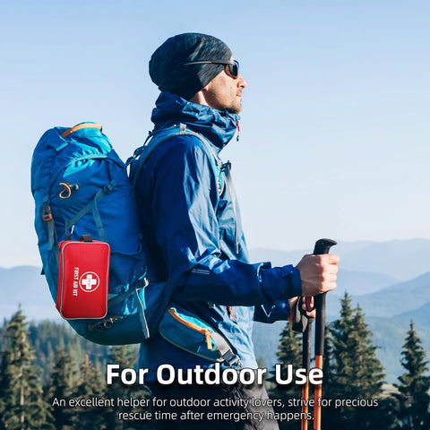 First aid kit, red compact pouch attached to blue hiking backpack outdoors