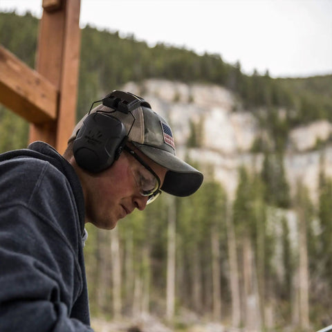Person wearing Xcel Digital Electronic Hearing Protection Earmuffs With Bluetooth And Voice Clarity For Hunters and Range Shooters.