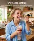 Woman enjoying soft chewable sonic ice from Nugget Ice Maker Countertop With Fast 8 Minute Ice, in a home kitchen setting.
