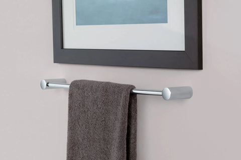 24 Inch Wall Mounted Chrome Towel Bar for Bathroom Organization and Storage holding a towel against a bathroom wall near framed art.
