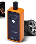 No Hassle Tpms Relearn Tool For Gm Cars El 50448 beside a car tire, showcasing its compact design and function.