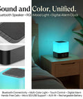 Five In One Night Light Bluetooth Speaker Alarm Clock MP3 Player With Touch Sensor LED Lamp on bedside table.