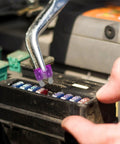 Person using a tester from the 100-Piece Auto Fuse Kit With Tall And Low-Profile Fuses And Circuit Tester, Plug-and-Play Quick-Replace For Cars, Trucks, SUVs, Boats. Universal Fit, Lightweight Durable, Perfect For DIY Electrical Fixes.