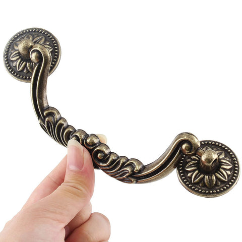 Close-up of decorative 5 Piece Drop Bail Cabinet Handle in bronze finish, showing intricate design and durable construction.
