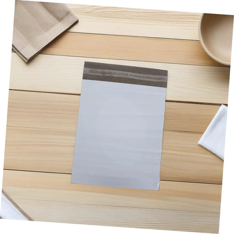 Waterproof Poly Mailer Bags 10x14 Inches White Self Seal Envelopes For Clothing on wooden surface