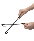 Hands holding the Badass Heavy Duty Dutch Oven Lid Lifter And Compact Folding Stand for safe lid handling.