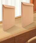 Two Kraft Mailing Envelopes 10 Pack With Double Sided Adhesive Seal on a wooden surface, 238x335x40mm, for documents and clothes