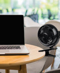 Clip On Fan Battery Operated With 360 Degree Rotation on table beside laptop
