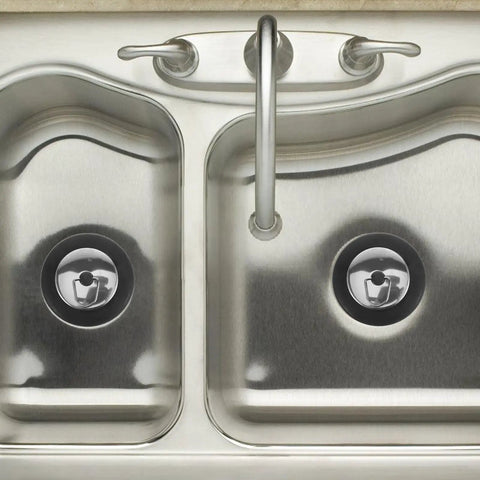 Rubber Bathtub Drain Stopper Plug with Stainless Steel Seal in a stainless steel sink; two drain openings visible.