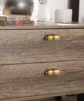 Six Pack 3 Inch Antique Brass Cup Pulls With Textured Strap Design installed on wooden dresser drawers.