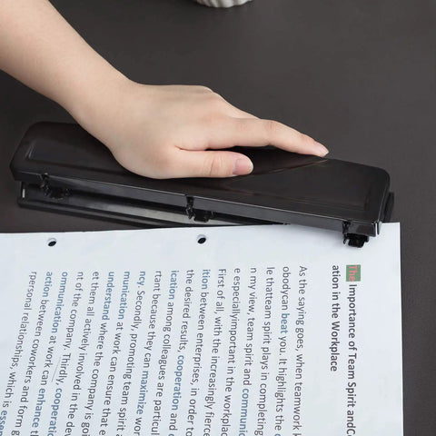Hand using Three Hole Punch For Office And Home Use No Fuss Ten Sheets Puncher With Durable Metal Construction Black Finish