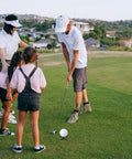 Family practicing golf on grass with Indoor Golf Practice Tees 20 Pack Tall And Short For Home Simulator And Driving Range Flexible Durable Tees
