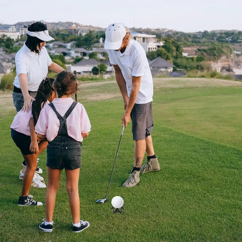 Family practicing golf on grass with Indoor Golf Practice Tees 20 Pack Tall And Short For Home Simulator And Driving Range Flexible Durable Tees