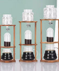 Portable Cold Brew Drip Tower Iced Coffee Maker Straight Up Smooth with glass jars and wooden stand for cold coffee brewing.