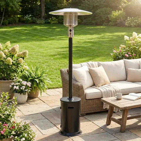 47000 BTU Outdoor Patio Heater With Round Table Design And Wheels Propane Gas Standing Heater With Double Layer 304 Stainless Steel Burner 20 Foot Radius Black Hammered Finish Perfect For Patios Decks And Backyards shown in a garden setting next to patio furniture.