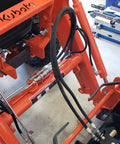 Orange skid-steer hydraulic quick-connect couplers with flat-face fittings on hoses; 3/4 in NPT thread.