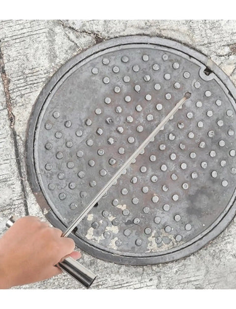 Hand using Heavy Duty Stainless Steel T Hook Drain Grabber For Manhole Covers And Heavy Grates on a manhole cover.