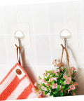 Super Tough Clear Adhesive Wall Hooks 12 Pack Stainless Steel Zero Mess Peel Strong Grip No Drill Install Holds Up Perfect For Kitchen Bedroom Hanging Setup You Gotta Get Your Hands On This, holding a towel and small plant.
