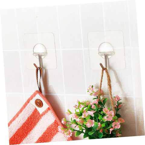 Super Tough Clear Adhesive Wall Hooks 12 Pack Stainless Steel Zero Mess Peel Strong Grip No Drill Install Holds Up Perfect For Kitchen Bedroom Hanging Setup You Gotta Get Your Hands On This, holding a towel and small plant.