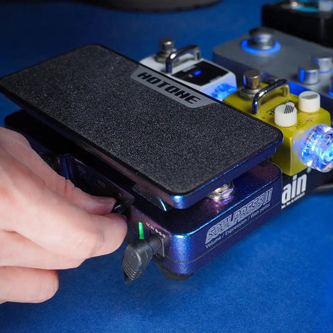 4 In 1 Guitar Effects Pedal With Active Wah, Expression, And Dual Volume Modes in use on blue surface