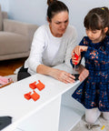 Child and adult assembling furniture with 4 Piece Woodworking Ratchet Band Clamp Blocks Set For Secure Frame And Corner Assembly.
