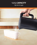 1.5L Cordless Electric Kettle With Cool Touch Exterior And Stainless Steel Interior pours into six white cups