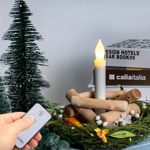 12 Pack Battery Operated Taper Candles With Remote, Warm White Flicker, Flameless LED in a decorative setting with greenery