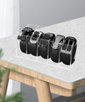 Upgrade Your Drawer Storage Vibe Today With This Sturdy Clear Acrylic Belt Organizer Designed With Five Flexible Foldable Sections To Store Ties And Belts on a table holding multiple black belts.
