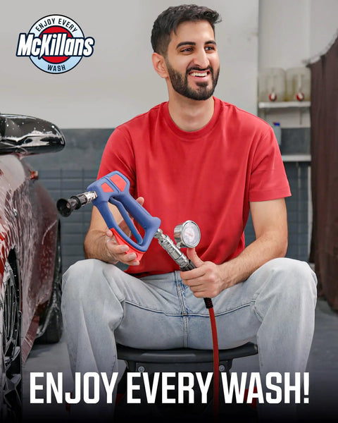 Man holding pressure washer handle near car, showcasing McKillans Wash branding, promoting enjoyment of car washing