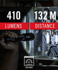 Person using HX5 410 Lumen LED Flashlight With Pure Beam Focusing And Slide Focus for long range lighting in a dark space.