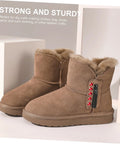 Side view brown suede fur-lined ankle boots with red rivet studs on the side and a black rivet tool