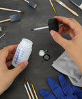 Person holding 6 Pack Empty Touch Up Paint Bottles 2 Oz Refillable Containers With Brush Applicator For Car Scratch Repair