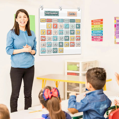 Teacher in class with Durable Nylon Classroom Calendar Pocket Chart For 2.75 By 2.75 Cards With 24 Inch Hanging on wall