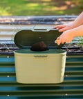 Heavy Duty Garden Tool Box Basil Green With Hinged Lid For Easy Access And Protection, attached to garden bed with a trowel