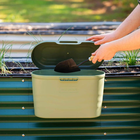 Heavy Duty Garden Tool Box Basil Green With Hinged Lid For Easy Access And Protection, attached to garden bed with a trowel