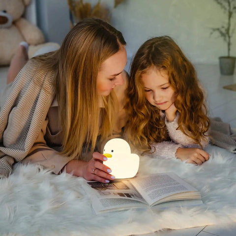 Mother and daughter reading with Duck Shaped Silicone Night Light For Nursery And Kids Room Cozy Warm White 2800K LED Lamp Safe BPA Free