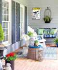 Outdoor patio with a Warning Construction Area Sign Aluminum 8x12 Inch Watch For Moving Equipment mounted on a grey wall.