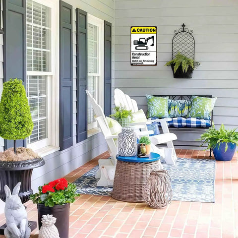 Outdoor patio with a Warning Construction Area Sign Aluminum 8x12 Inch Watch For Moving Equipment mounted on a grey wall.
