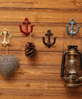 Badass Vintage Cast Iron Nautical Anchor Wall Hooks For Bathrooms And Closets on wooden wall with decorative items.