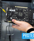 Person using adjustable ESD wrist strap with grounding cord while holding a graphics card for PC building and electronics repair.