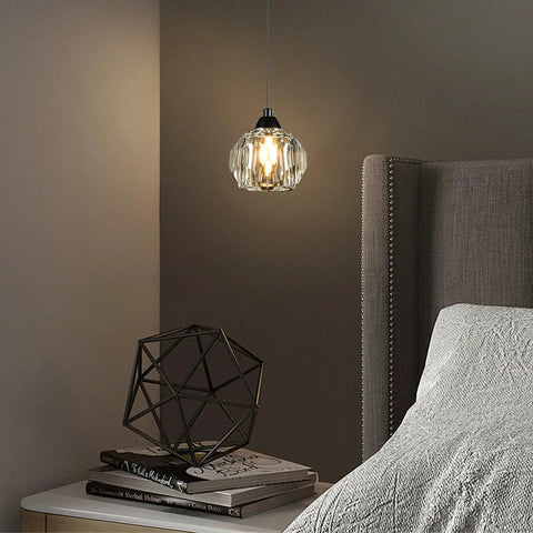 Three Light Matte Black Pendant Lighting With Transparent Glass Shades over bedside, industrial retro style.