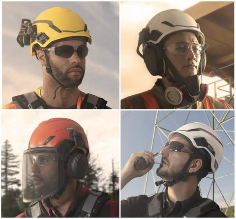 Four workers wearing V-Gard safety helmets in different colors with Fas-Trac III ratchet suspension and accessories onsite.