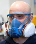 Man wearing Pro Grade Half Mask Respirator With Reusable Filters And Safety Glasses For Dust Pollen And Organic Vapor Protection
